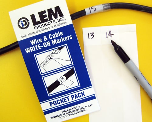 A book of self-laminating wire markers with a white, write-on area and a clear sealing tail.