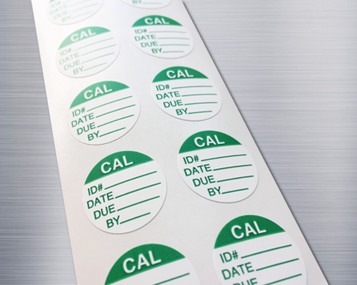 A strip of circular quality control labels with space for hand written information.