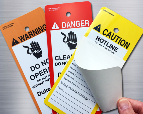 An image of three accident prevention tags: an orange and white warning tag, a red and white danger tag and a yellow and white caution tag.
