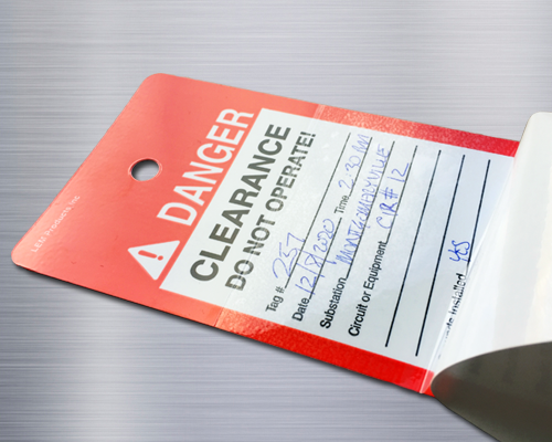 A danger tag with hnd-written information and a self-sealing cover.