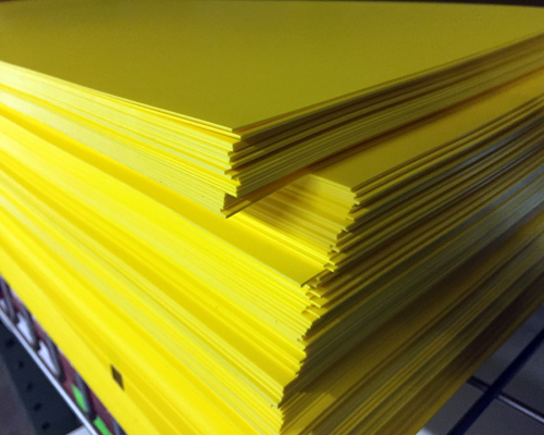 A stack of rigid yellow plastic sheets